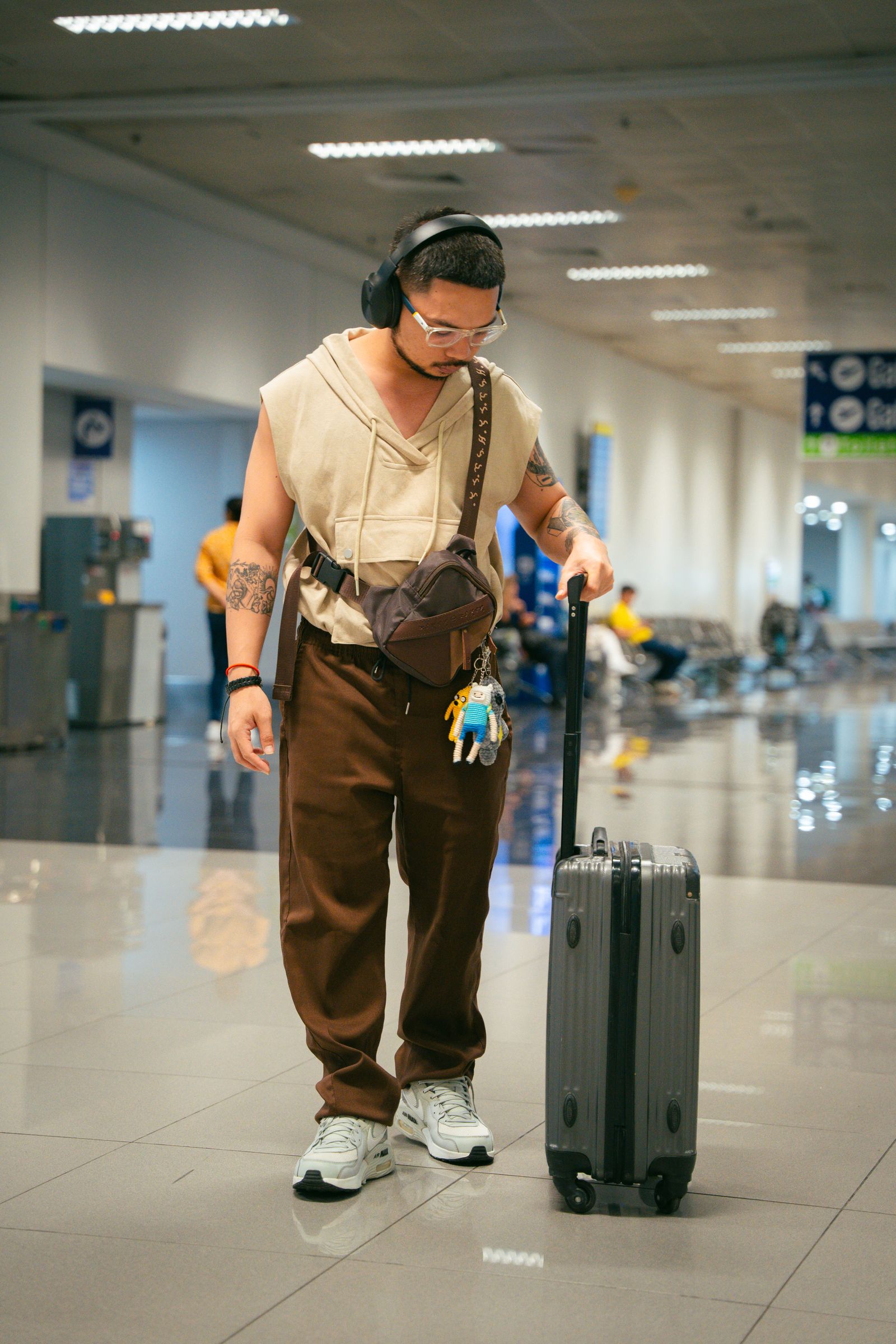 A young traveller arriving at an airport with a suitcase